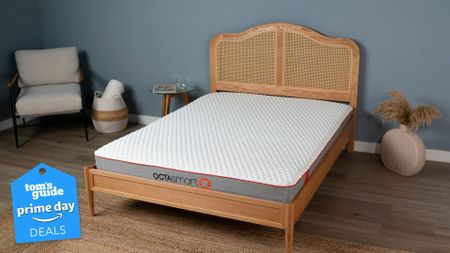 The Octasmart Deluxe Memory Foam Mattress in a light blue bedroom. A Prime Day deals badge can be seen in the bottom left foreground. 