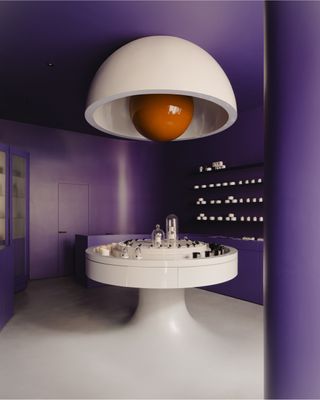 a purple futuristic looking perfume store with a large light fixture over head