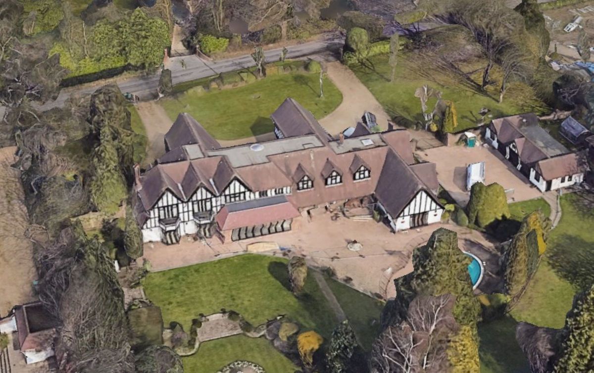 The rear of the property from a view above shows a tennis court and swimming pool