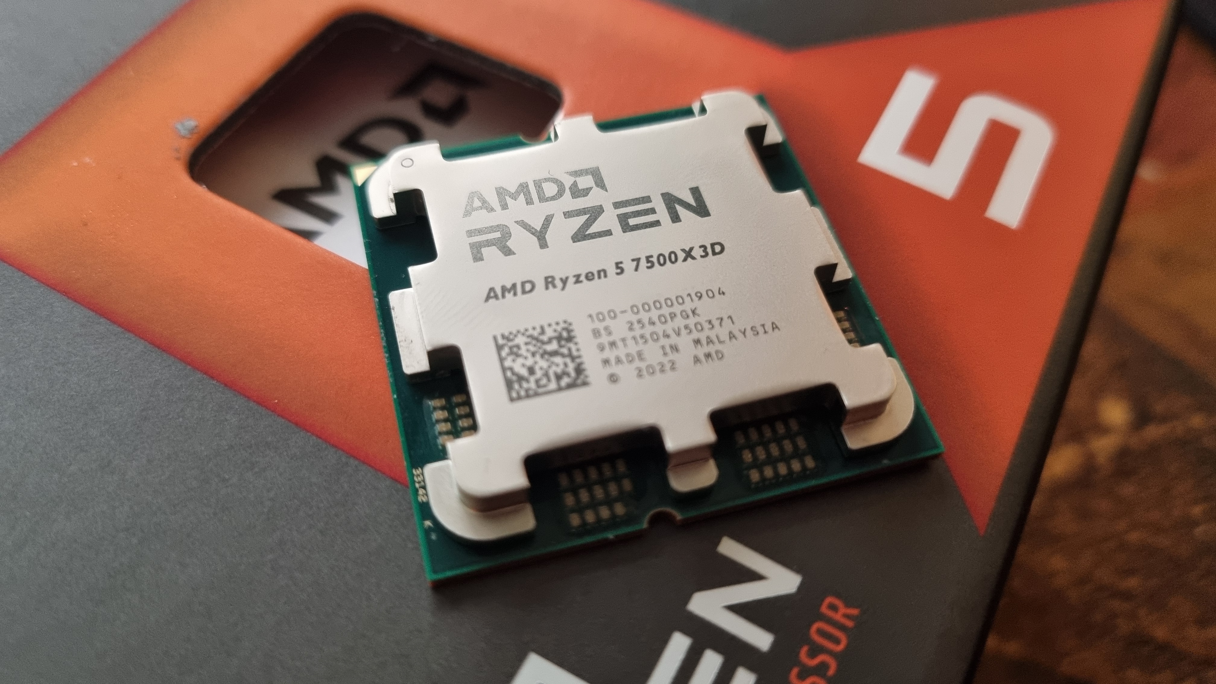An AMD Ryzen 5 7500X3D CPU on top of its packaging