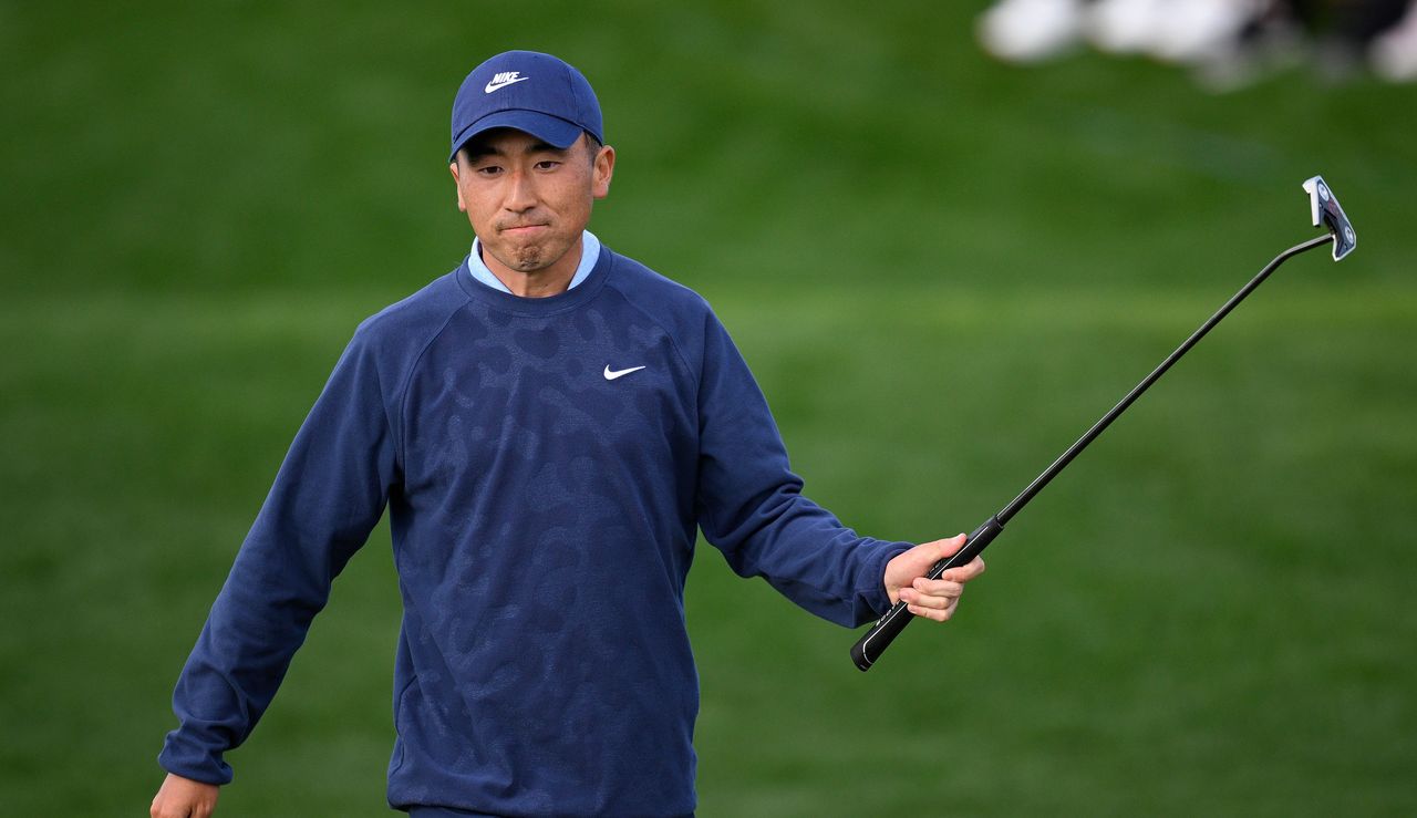 Doug Ghim raises his putter in the air after holing a putt