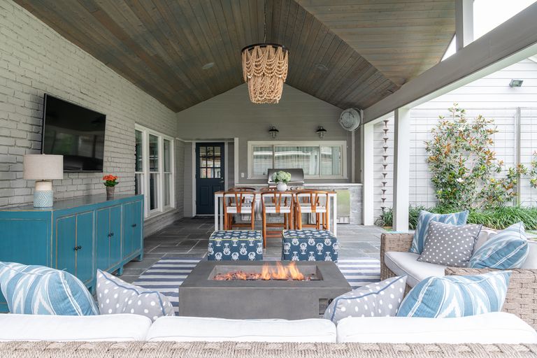 outdoor living room with tv on the wall, blues and neutral scheme 