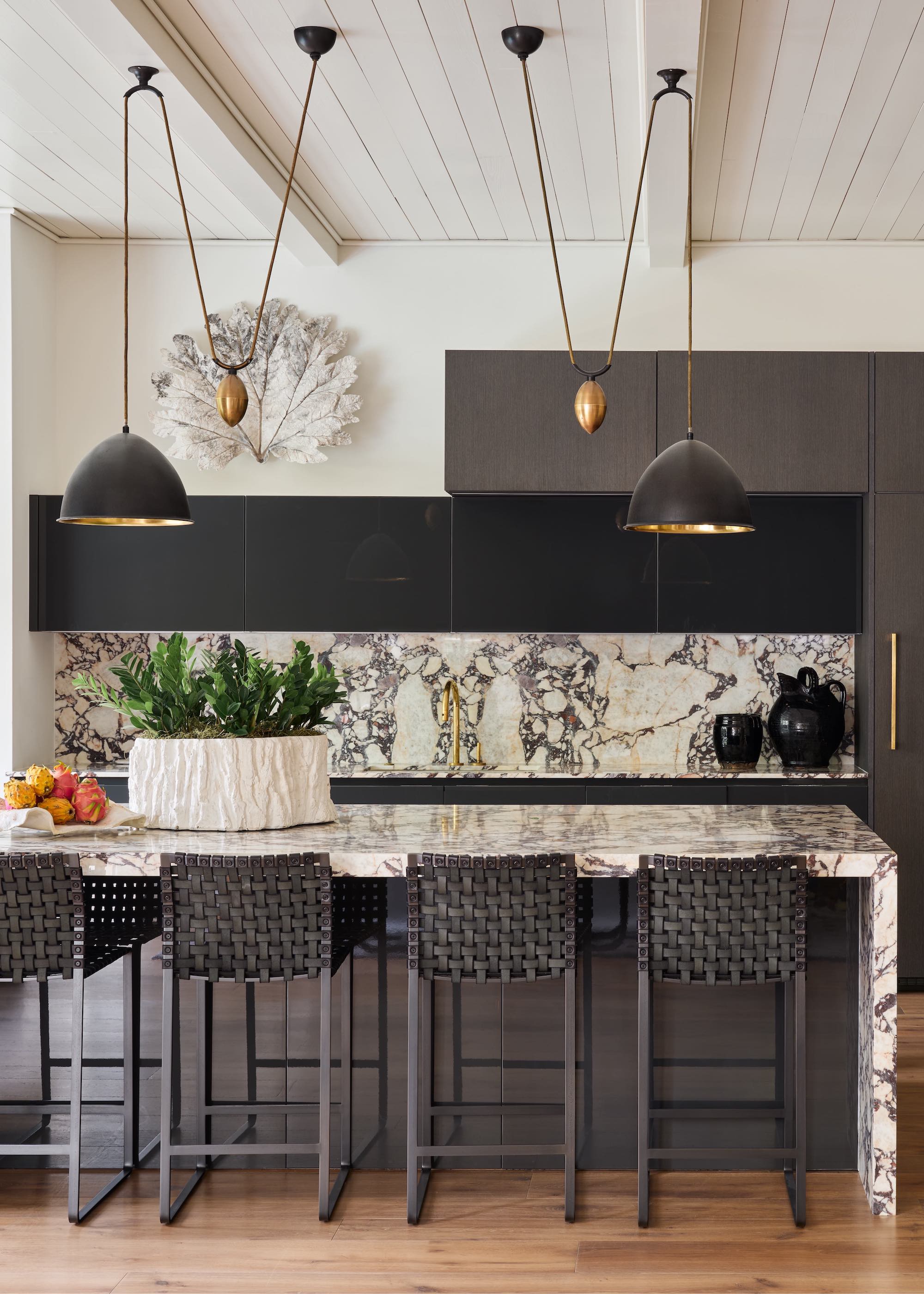 black kitchen cabinets with black and white marble island and backsplash