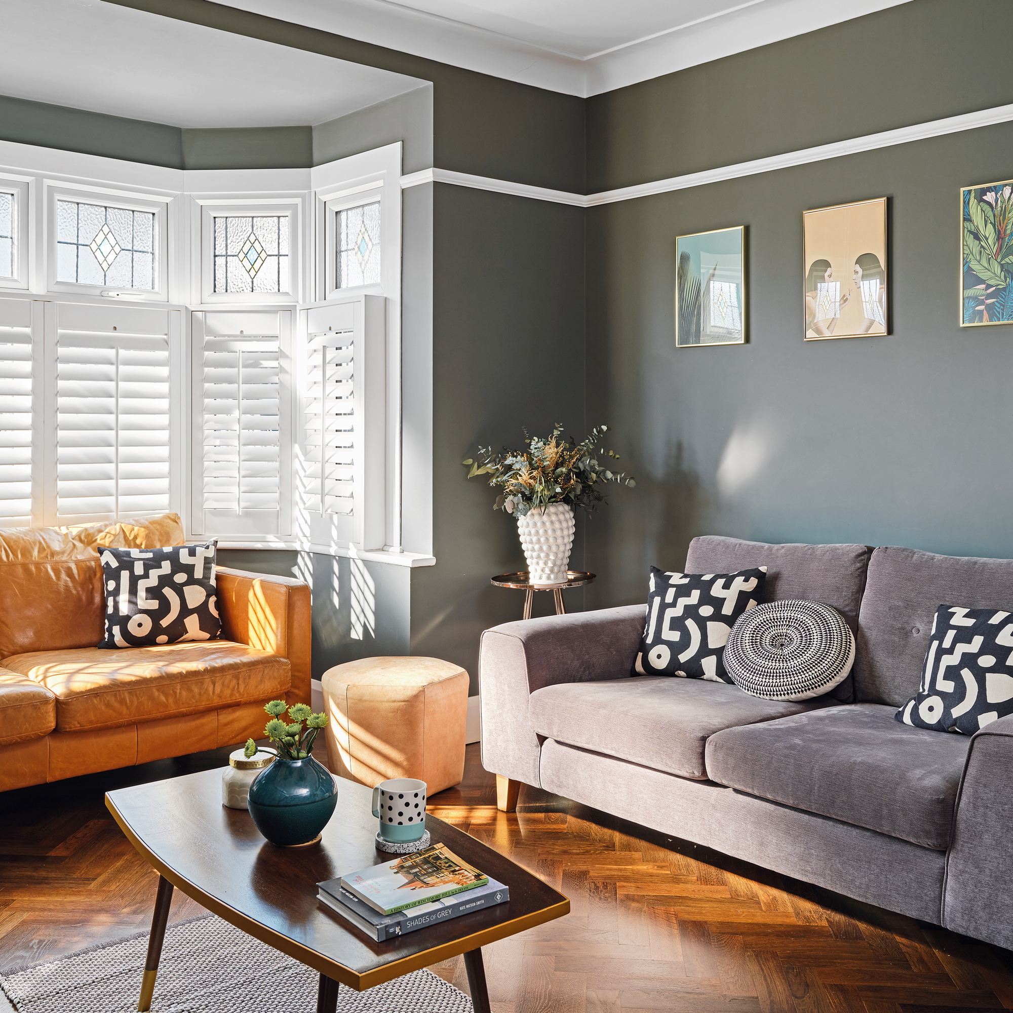 a green grey living room with parquet flooring, a yellow and a grey sofa and a mid century coffee table