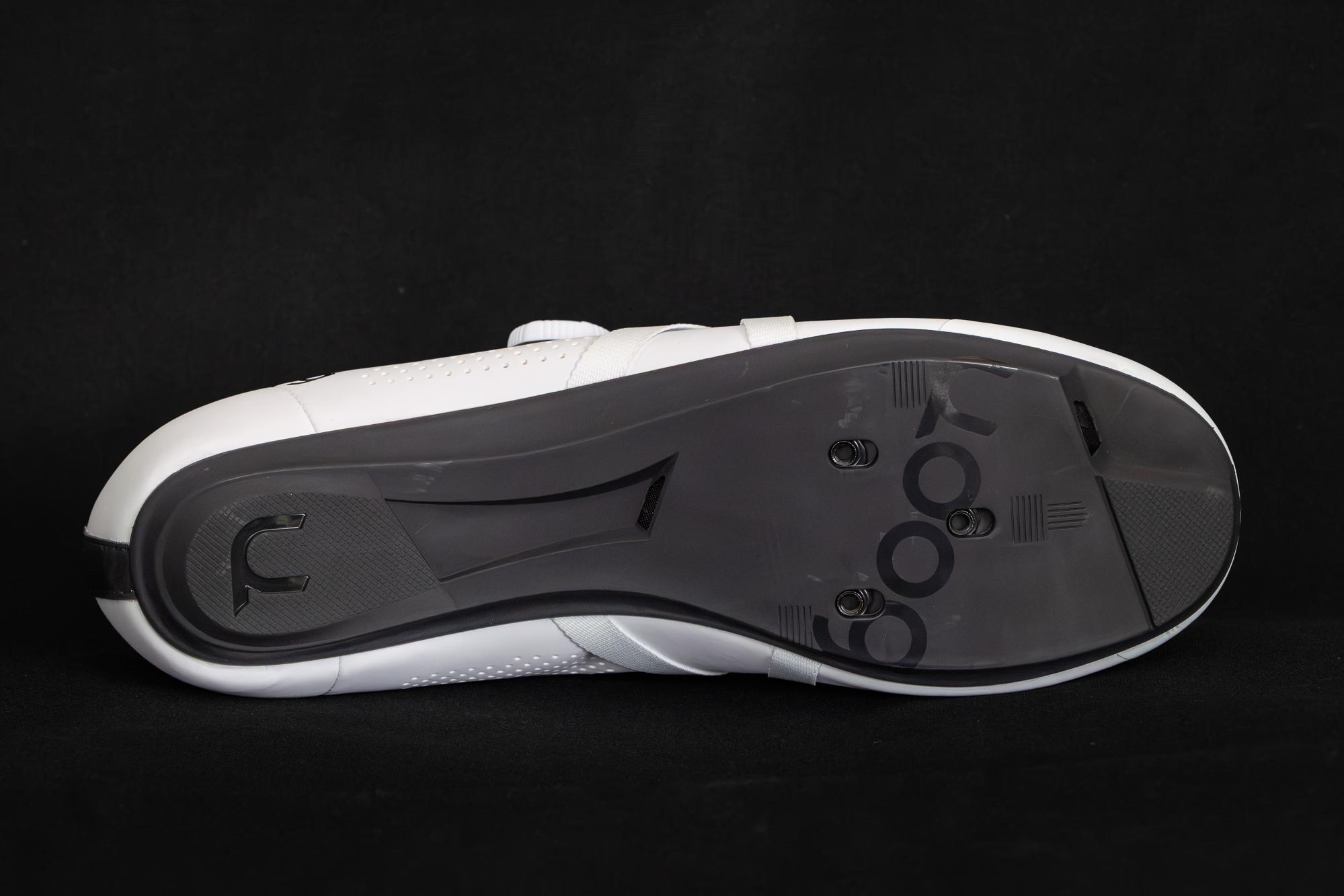close up of the black sole of a white cycling shoe