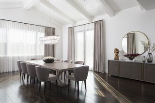 A large dining room with a twelve-seater table and neutral furnishings