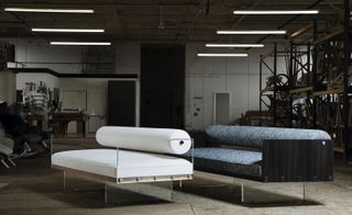 Two sofas comprising a simple composition of essential forms in lucite and wood with a rolled back cushion
