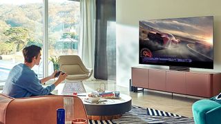 A man playing a video game on a Samsung QN90A in his living room