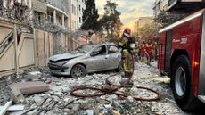 First responders gather outside a building hit by an Israeli strike in Tehran last Friday