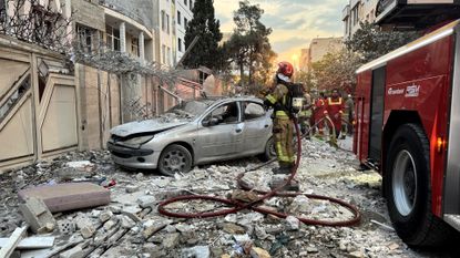 First responders gather outside a building hit by an Israeli strike in Tehran last Friday