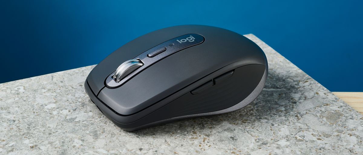 A photo of the Logitech MX Anywhere 3S mouse on a stone surface with a blue wall in the background.