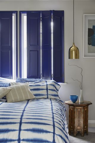 blue bedroom shutters in a blue and white bedroom
