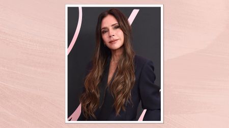 Image of Victoria Beckham smiling with curly long brunette hair and wearing a black blazer, on a pink watercolour background