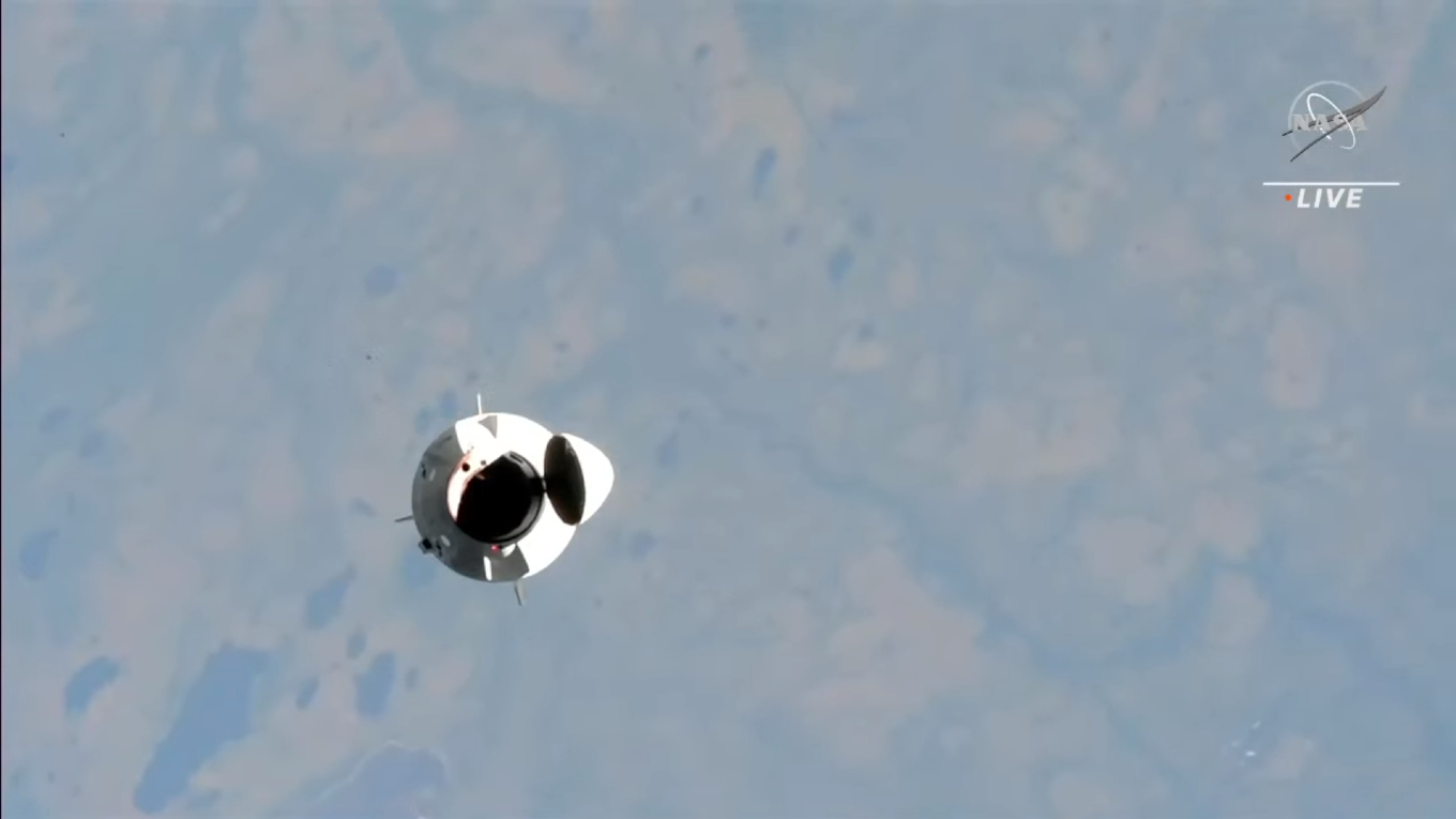 A space capsule with the blue edge of Earth behind