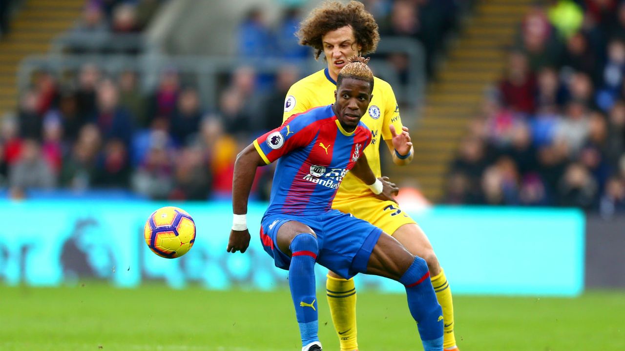 Crystal Palace forward Wilfried Zaha is challenged by Chelsea defender David Luiz 