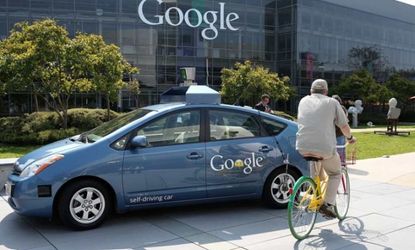 A cyclist rides past one of Google's self-driving cars outside the company's headquarters in California.