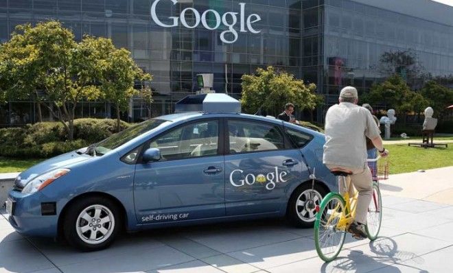 A cyclist rides past one of Google&amp;#039;s self-driving cars outside the company&amp;#039;s headquarters in California.