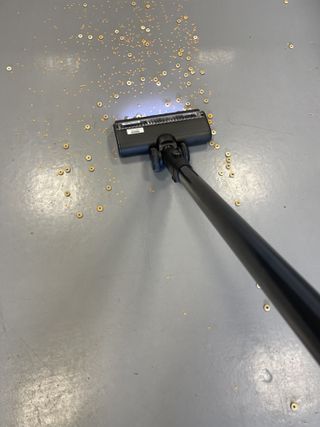 Tineco Pure One Station vacuuming cereal and lentils on linoleum floor