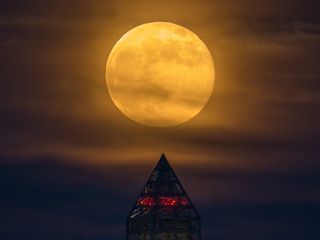 a supermoon climbs its way to the top of the Washington Monument, Sunday, June 23, 2013.