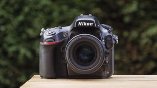 Bästa systemkamera: En Nikon D800 står placerad på ett träbord utomhus.