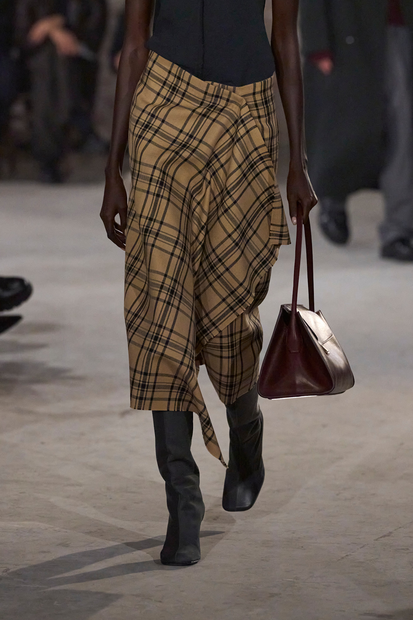 Photo of model on runway wearing checkered plaid maxi skirt.