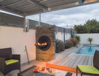 Sigma Focus wall mounted fire pit in black in a covered outdoor area