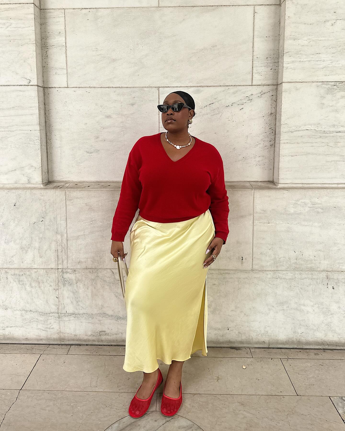 Tendências de saia para o verão de 2025: @aniyahmorinia usa saia amarelo-manteiga com acessórios vermelhos