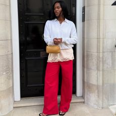Marilyn wears a white top, pink lace top, red jeans, and the row 90s bag in tan.