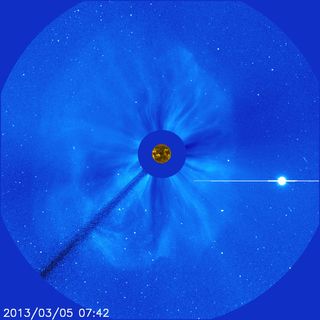 This image of a coronal mass ejection, or CME, was taken by NASA’s Solar and Heliospheric Observatory, or SOHO, on March 5, 2013. This event is a halo CME, named for the way the glowing cloud of solar material spreads out in a faint circle around the sun’s disk. Before SOHO discovered the solar tsunamis that often happen in close conjunction with CMEs, scientists generally had no way of knowing if a halo CME was heading directly toward or directly away from Earth. The large, bright spot in the lower right of the image is Venus.