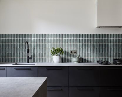 An example of kitchen tile costs showing a kitchen with gray cabinets and green wall tiles behind the worktop below a white wall