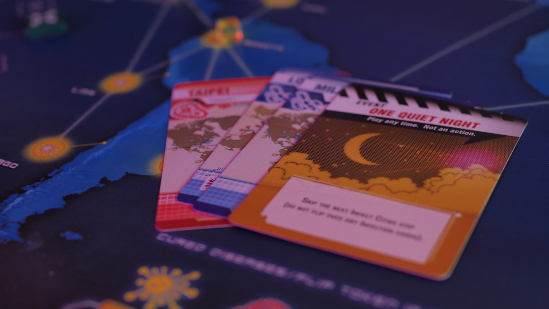Pandemic board, cards, and tokens on a wooden table