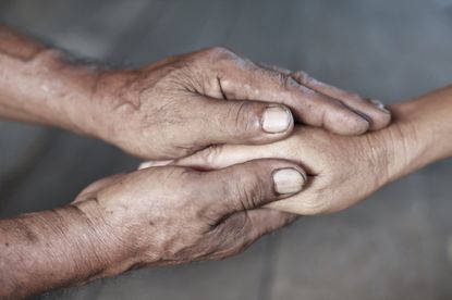 Two adults hold hands