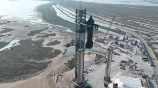 SpaceX's "Mechazilla" launch tower stacks the Ship 24 Starship prototype atop the Booster 7 Super Heavy vehicle at the company's Starbase facility in South Texas in this image, which is a screenshot from a video SpaceX posted on Twitter on Jan. 9, 2023.