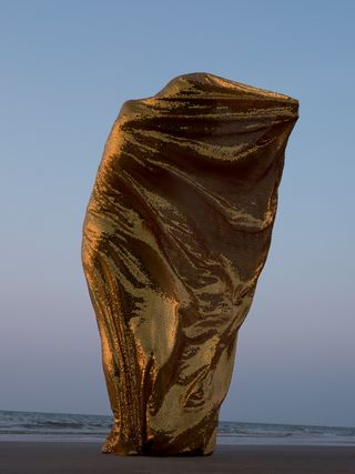 A person wrapped in golden fabric.
