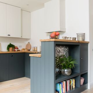 storage shelves at the back of green painted kitchen cabinet with wooden counter tops