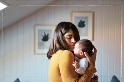 young mother cradling new born baby at home