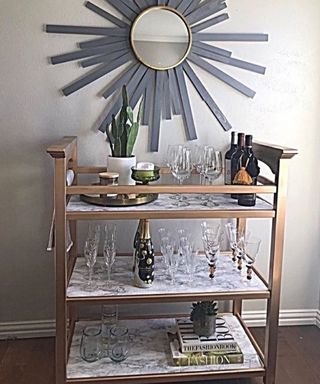 A DIY bar cart made from a diaper changing table and marble-effect contact paper
