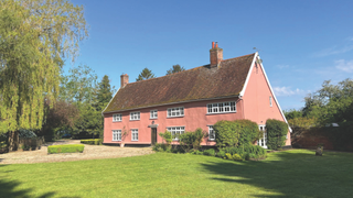 Rose colored house with front gardens