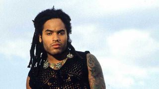 Lenny Kravitz on a beach with clouds behind him