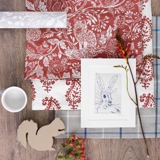 Flat lay of patterned fabrics, flowers and prints