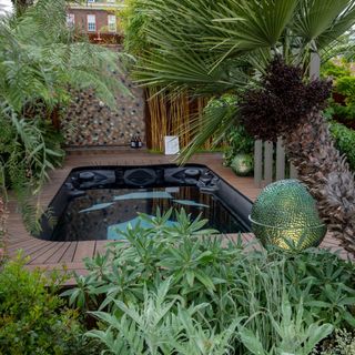 Small garden is small swimming pool with wooden deck
