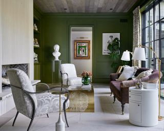 Living room with green walls, fireplace, couch and armchairs