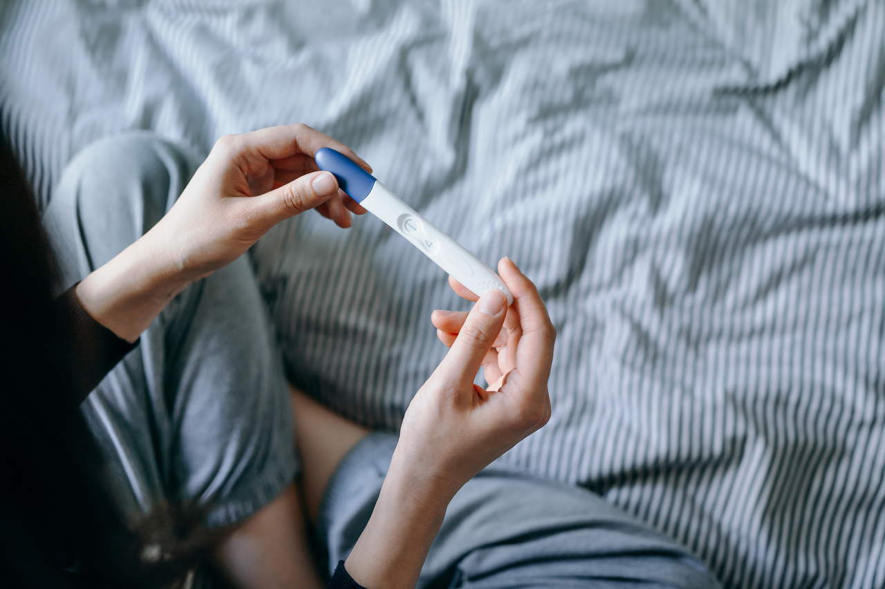 Woman looking at a negative pregnancy test as she wonders, why can&#039;t i get pregnant