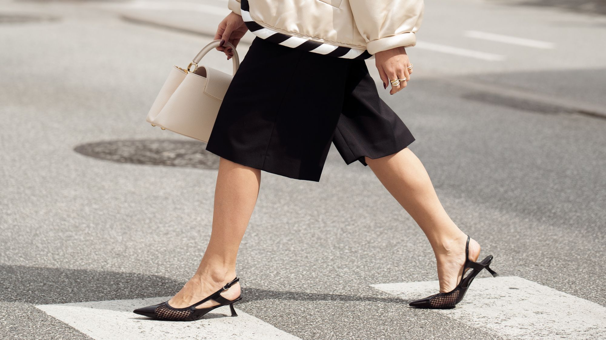 woman walking across the road in shorts and kitten heels