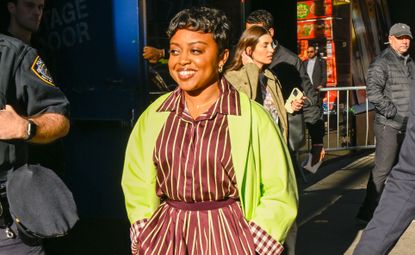 Quinta Brunson attending a morning show taping wearing a burgundy and brat green outfit