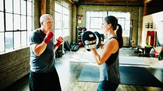 Man boxing with trainer