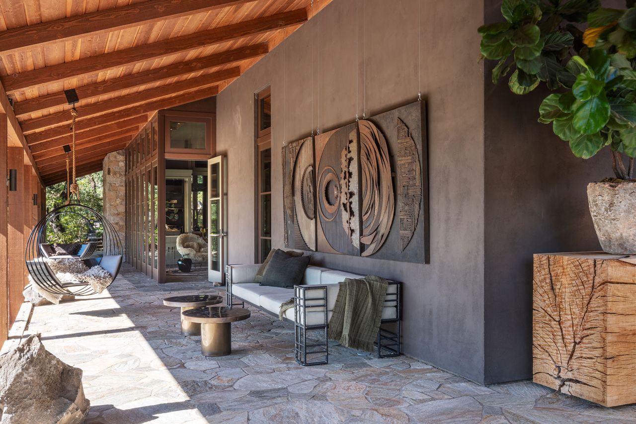 Covered patio area using outdoor metal and wood materials, metal hanging egg chair