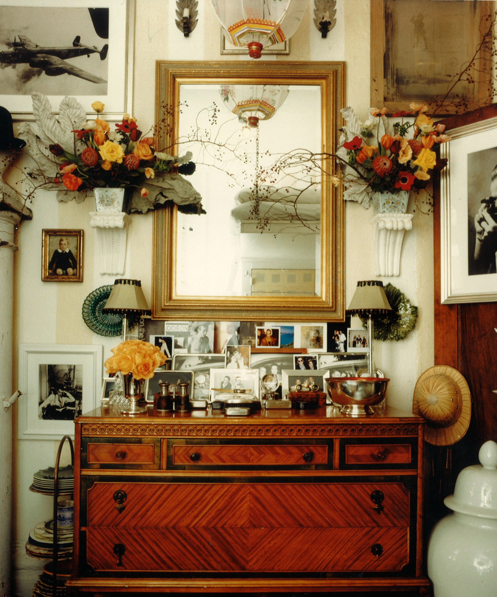 vintage cabinet with vintage postcards and lamps and a mirror on it
