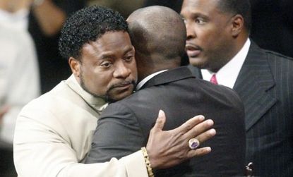 Bishop Eddie Long embraces a friend during a service last September: The megachurch pastor settled his sexual coercion lawsuit out of court.
