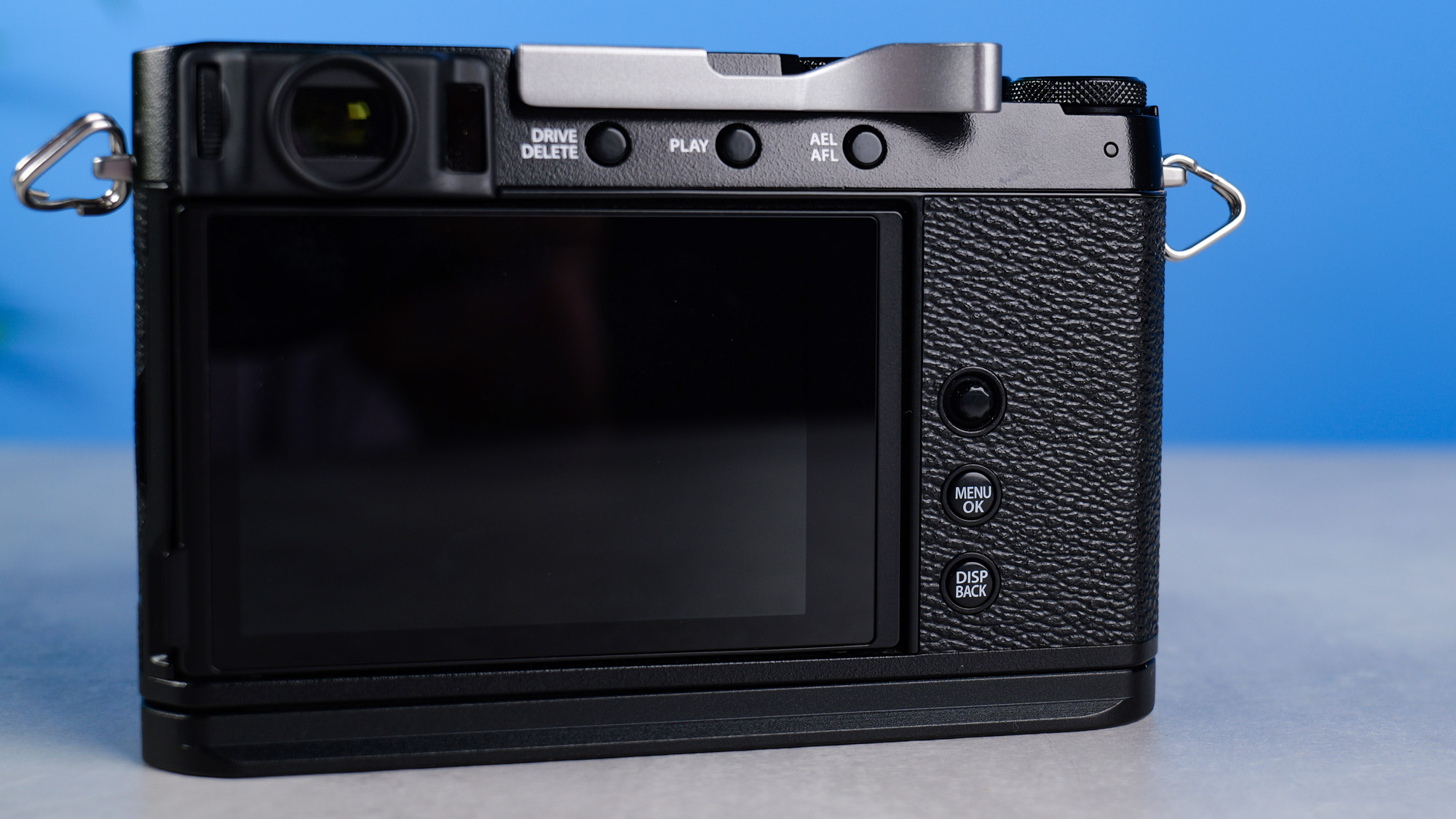 Fujifilm X-E4 on a stone surface and blue background